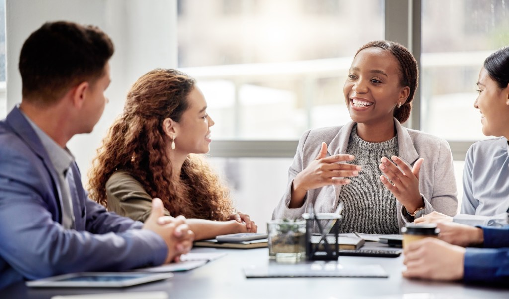 Discussion, meeting and business people in office for teamwork, planning or review at table. Collaboration, professional and group of diverse employees for ideas, conversation or project development.